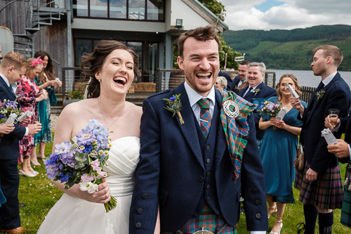 Bride and groom laughing during confetti throw