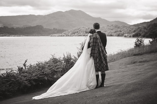 Bride and groom looking towards a mountain in Scotland